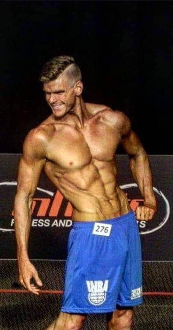 Chris on stage at a physique competition, 40kg lighter